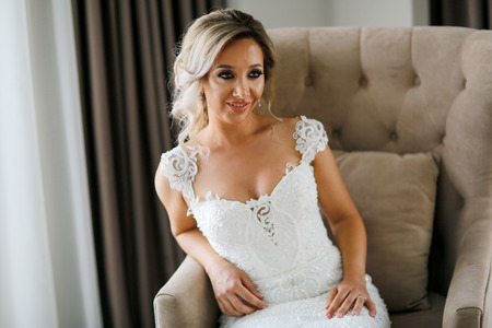 Beautiful blonde bride posing in luxury roomの写真素材