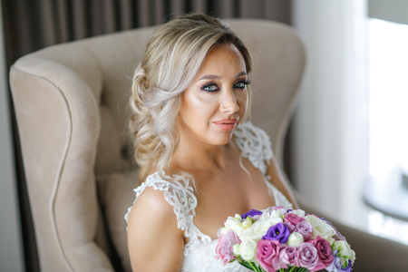 Beautiful blonde bride posing in luxury roomの写真素材