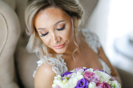 Beautiful blonde bride posing in luxury roomの写真素材
