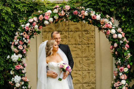 Beautiful wedding couple posing in park in front of Rose Crownの写真素材