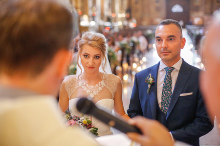 Young beautiful wedding couple at the old catholic churchの写真素材