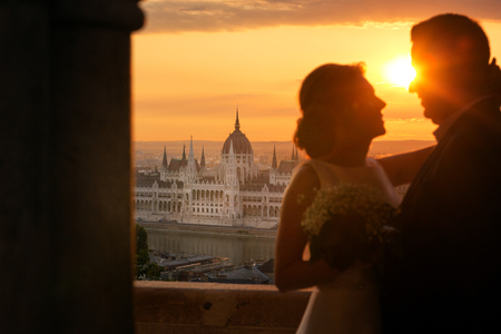 Silhouette of beautiful wedding couple posing in sunの写真素材