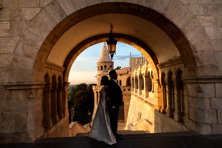 Silhouette of beautiful couple posing in old castle at sunriseの写真素材