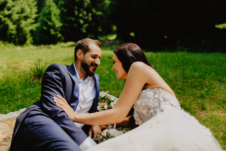 Beautiful wedding couple posing in nature on traditional carpetの写真素材