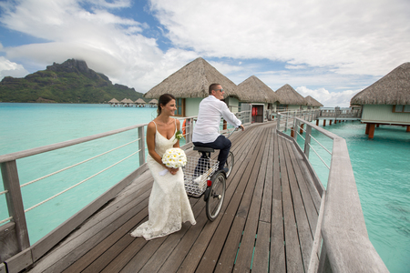 Beautiful wedding couple posing on dock near houses at Bora Boraの写真素材