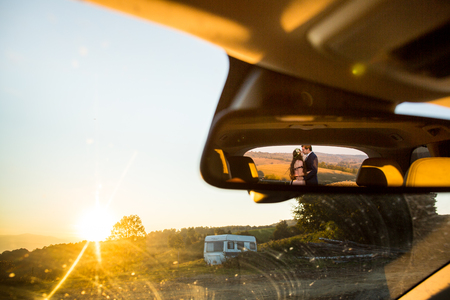 Beautiful view from car mirror with beautiful wedding couple in natureの写真素材