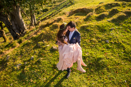 Beautiful wedding couple posing on green hillsの写真素材