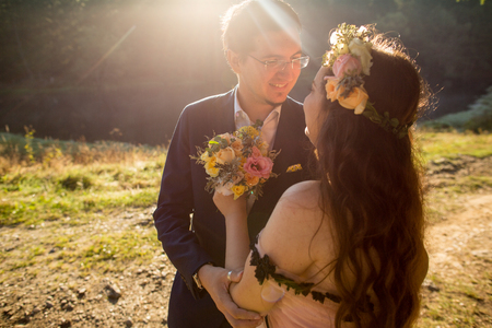 Beautiful wedding couple posing on green hillsの写真素材