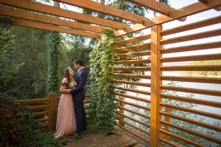Beautiful wedding couple posing outdoor in forest on wooden dockの写真素材