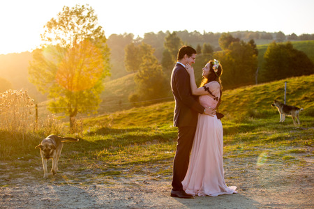 Beautiful wedding couple posing on yard. Romantic wedding sunset.の写真素材