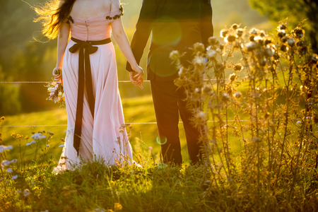 Beautiful wedding couple posing on yard. Romantic wedding sunset.の写真素材