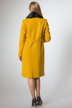 Beautiful blonde girl posing in yellow coatの写真素材