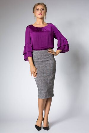 Beautiful blonde girl posing in purple dressの写真素材