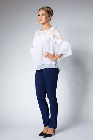 Beautiful blonde model posing in white shirt and blue pantsの写真素材