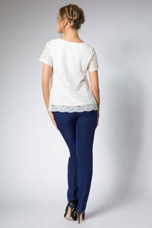 Beautiful blonde model posing in white shirt and blue pantsの写真素材