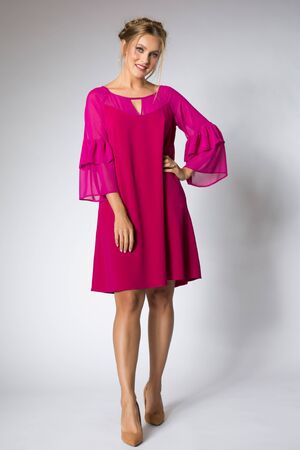 Beautiful blonde model posing in pink dressの写真素材