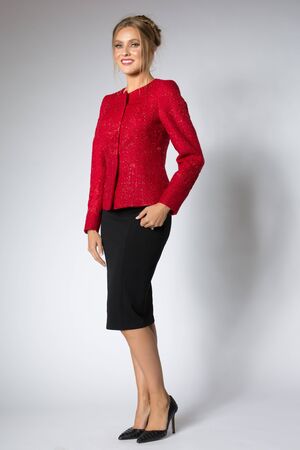 Beautiful blonde girl posing in red sweater and black dressの写真素材