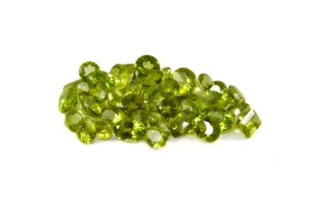 A groupn of mixed faceted peridots on a white backgroundの写真素材