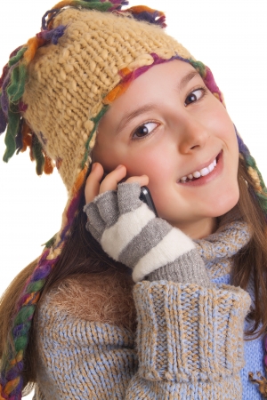 Beautiful young girl in warm winter clothes talking on her cell phoneの写真素材