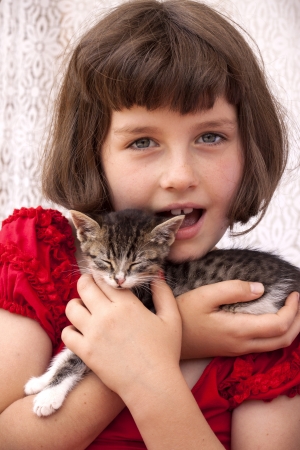 Little girl holding kitten. Outdoorの写真素材