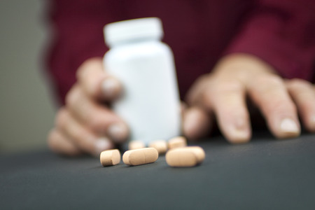 Hands Of Woman Deformed From Rheumatoid Arthritis holding pillsの写真素材