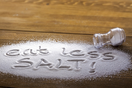 Eat less salt written on a heap of salt - antihypertensive campaignの写真素材