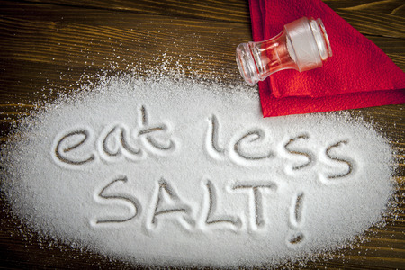 Eat less salt written on a heap of salt - antihypertensive campaignの写真素材