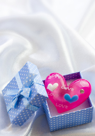 Blue present box with little pink heart of glass. For maleの写真素材