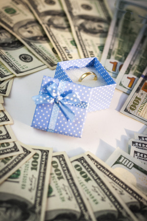 Wedding ring in blue box. American dollars aroundの写真素材
