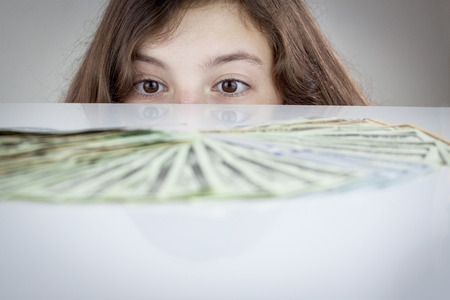 Teen girl looking at US dollars. Blurredの写真素材