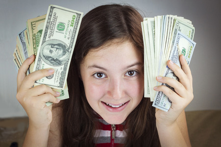 Beautiful teen girl holding US dollars. Happy face expressionの写真素材