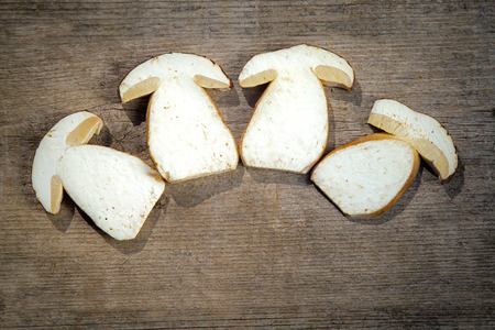 Fresh white slices of Boletus Edilus mushrooms on a brown wooden tableの写真素材