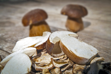 Boletus Edilus mushrooms on a wooden table  â€“ fresh dried and sliced, blurry background