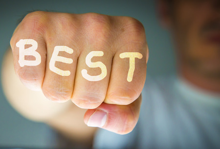 BEST written on the fingers of an angry mans fists. White letters. Message concept image.の写真素材