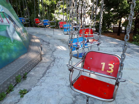 Red and blue baby amusement ride seats on a chain. Quarantined.Carousel.