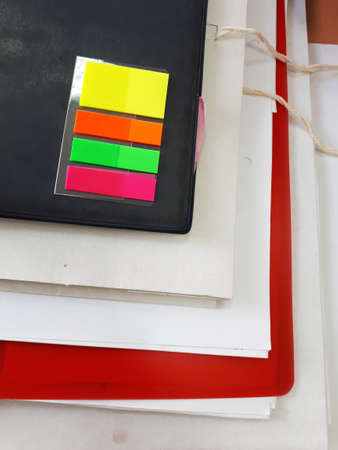 White, black and red notebooks and folders for papers. Workplace. Colored bookmarks.
