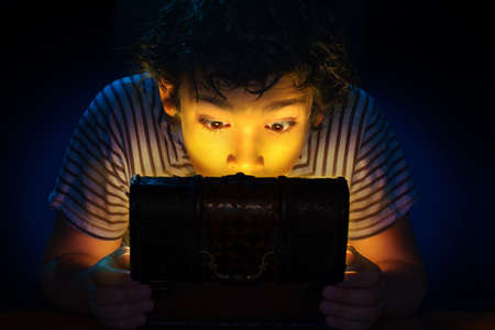 A surprised child look at a treasure chest