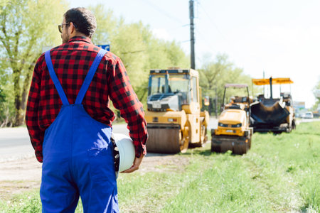 Engineer orders for workers to work safely at construction site, workers put asphalt on the roadの写真素材