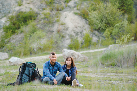 Couple enjoying beautiful views on the mountains, while traveling with backpacks in the mountains...