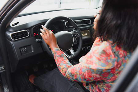 happy african woman driving a new carの写真素材