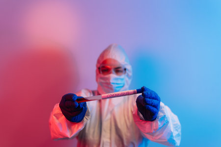 Doctor's hands fill syringe with coronavirus vaccine, preparing for injection. Covid-19 protection. Pandemic, epidemic, vaccination concept. Testing new vaccine. Doctor in protective suitの写真素材