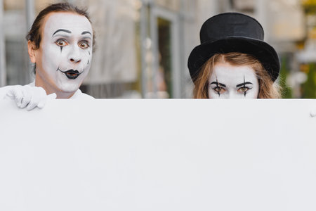 your text here. Actors mimes holding empty white letter. Colorful portrait with gray background. april fools dayの写真素材