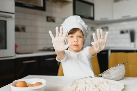 Little boy in the kitchen.Cute boy wears a chef hat and apron.