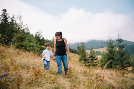 Young mom with baby boy travelling. Mother on hiking adventure with child, family trip in mountains. national park. Hike with children. Active summer holidaysの写真素材