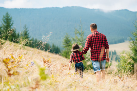 Happy father and little child are walking in the mountains. father's day. vacation in the national...