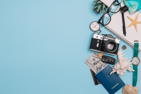 Preparation for Traveling concept, watch, airplane, money, passport, pencils, book, Photo frame, eyeglass on blue background with copy spaceの写真素材