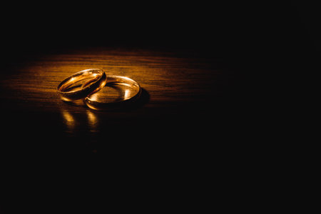 Beautiful wedding gold rings on dark backgroundの写真素材