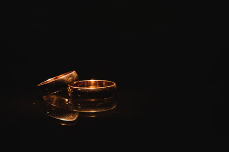 Beautiful wedding golden rings on dark backgroundの写真素材