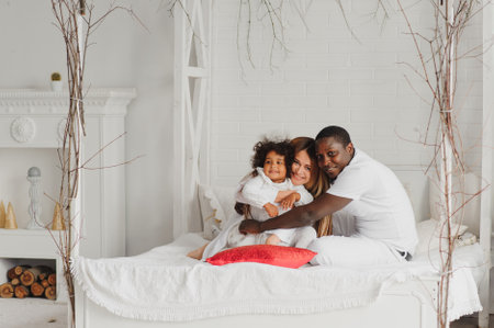 Happy interracial couple with their little daughter at homeの写真素材
