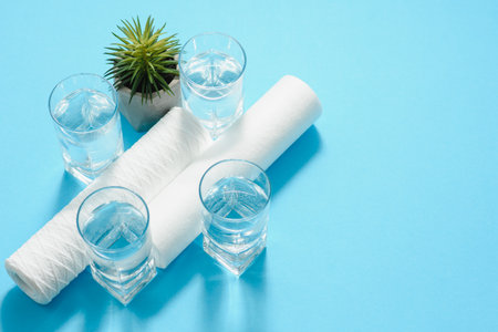 A glass of water on the background of filter cartridgesの写真素材